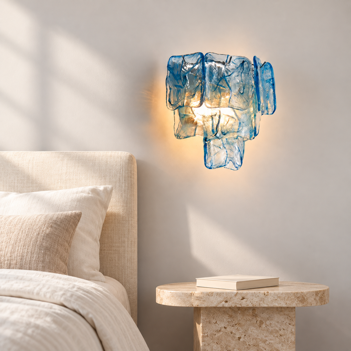 Marea Fold blue glass and silver frame wall sconce in a bright bedroom scene