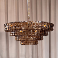 Smoke glass chandelier shown unlit with curved panels and brass finish frame